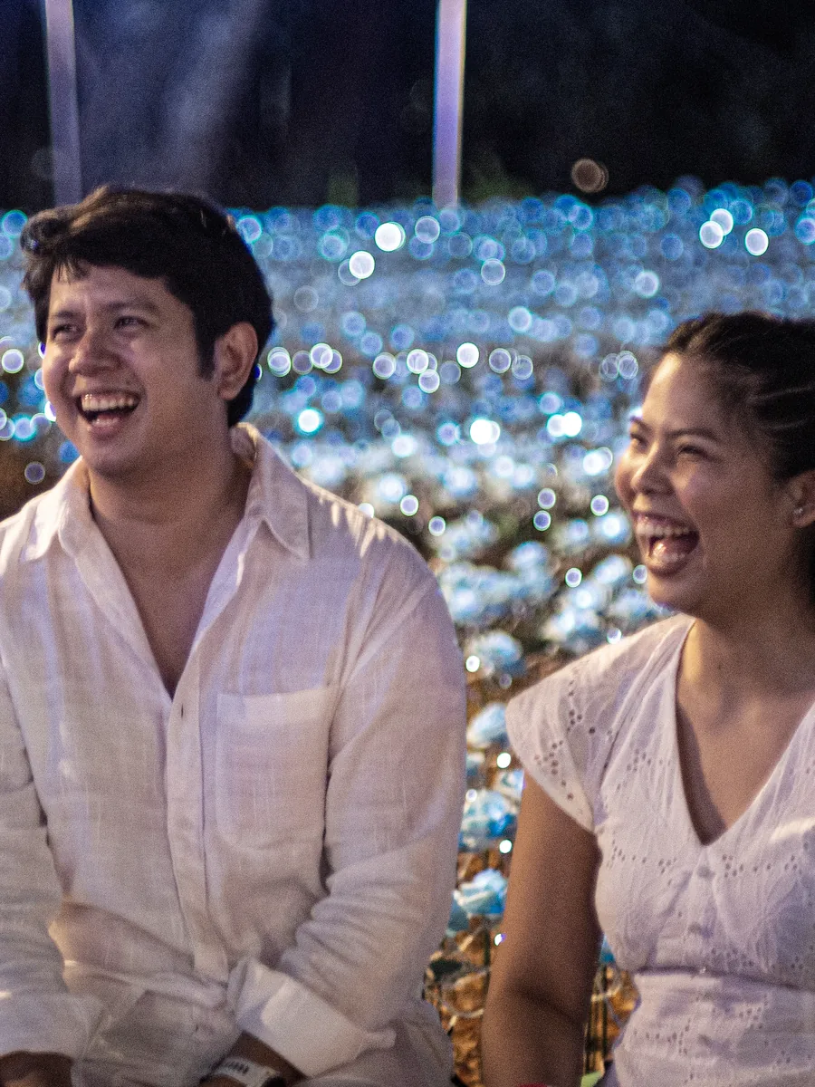 Tommy and Jeyan laughing together among soft lights