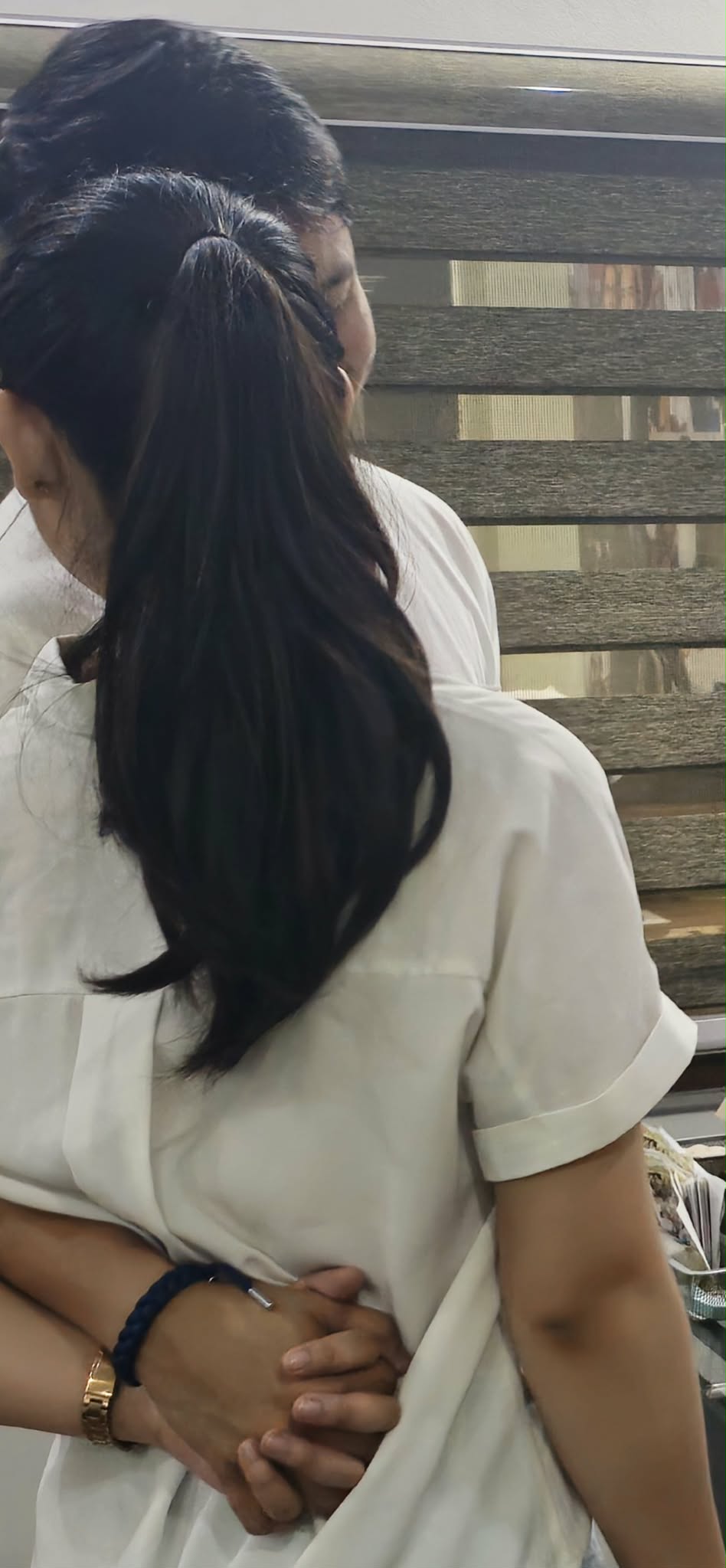 Tommy and Jeyan embracing in white on the day of their civil wedding
